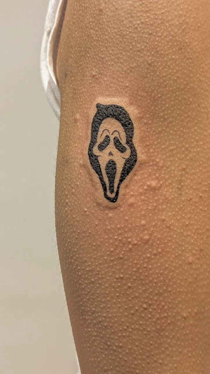 Ghostface mask in solid black on the arm