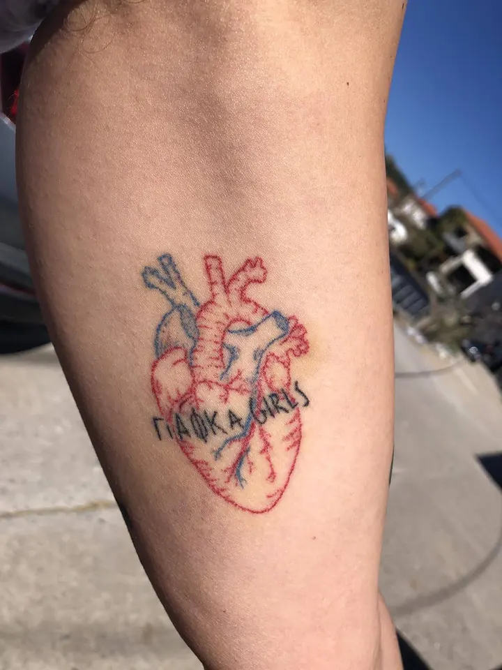 Anatomical heart in red and blue with lettering, on the arm