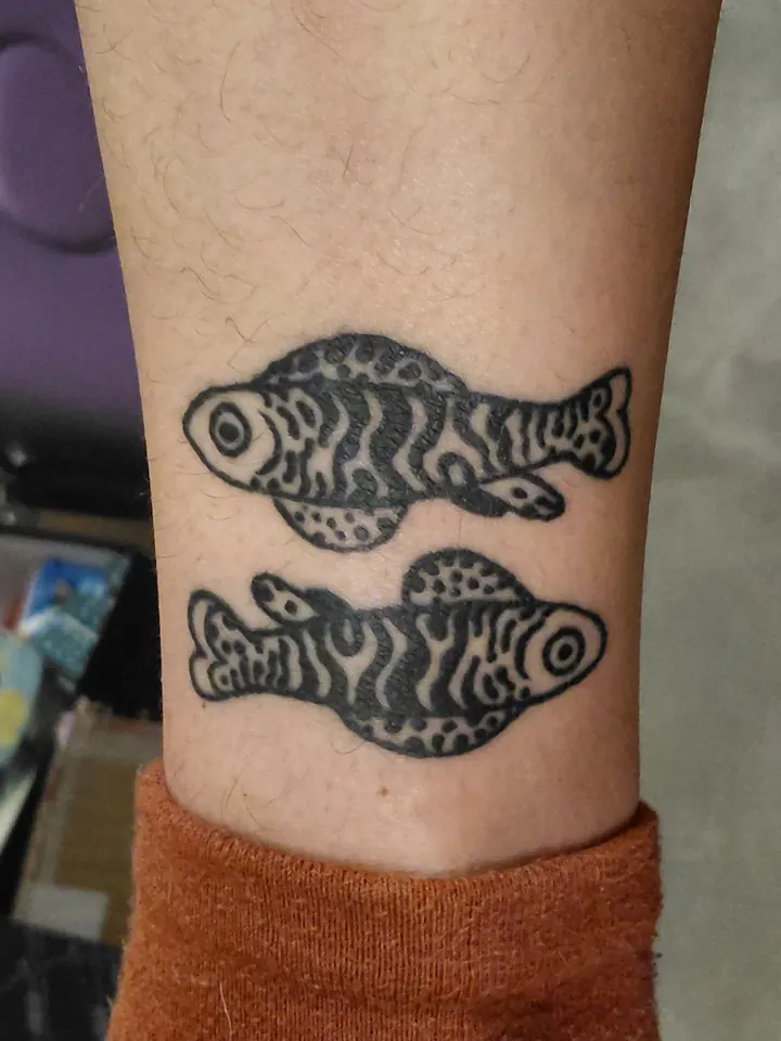 Cover-up, before: two black fish on the lower leg