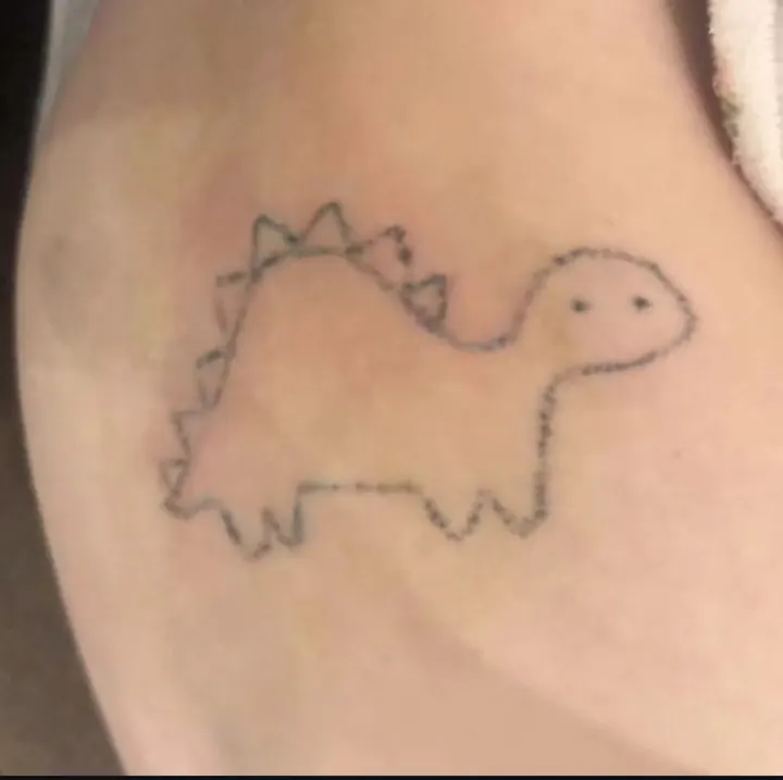 Cover-up, before: a faded, dotted dinosaur outline