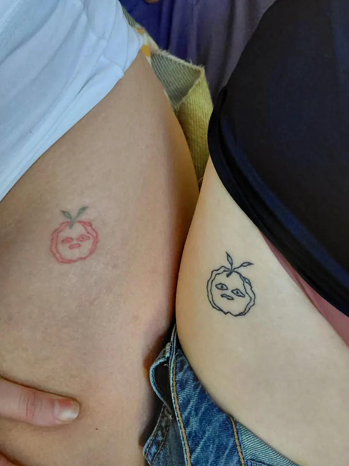 Matching fruit with little faces, one red and one black, on two hips