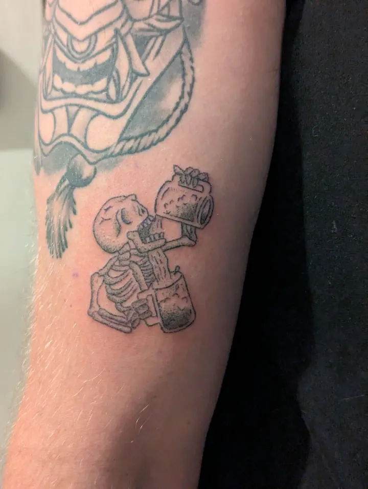Skeleton drinking from a jug, on the arm