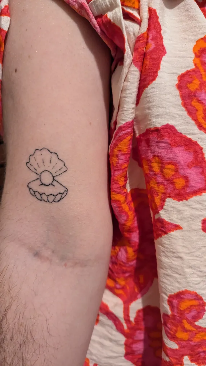 Open shell with a pearl on the arm