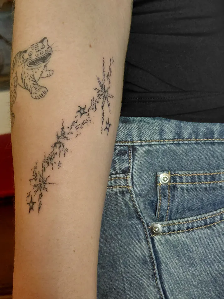 Small tiger and a trail of sparkles on the arm