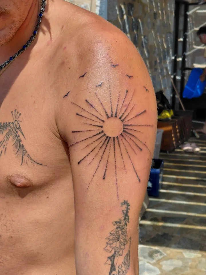Sun with long rays and small birds on the shoulder