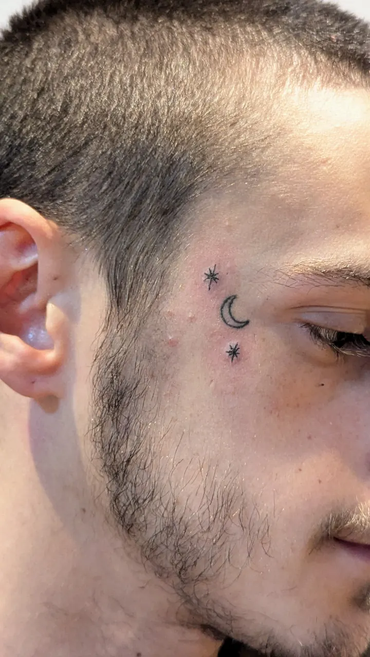 Tiny stars and a crescent moon beside the eye