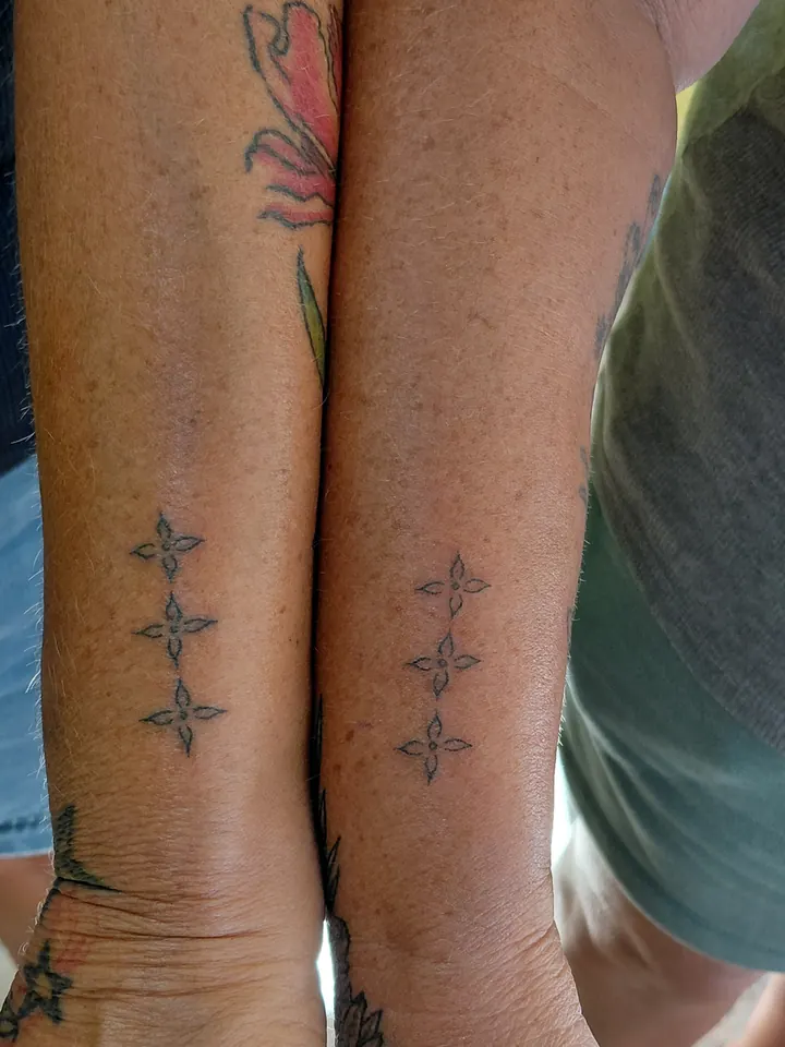 Matching small four-pointed stars on two forearms