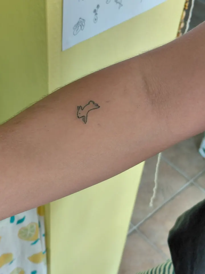 Tiny leaping rabbit on the forearm