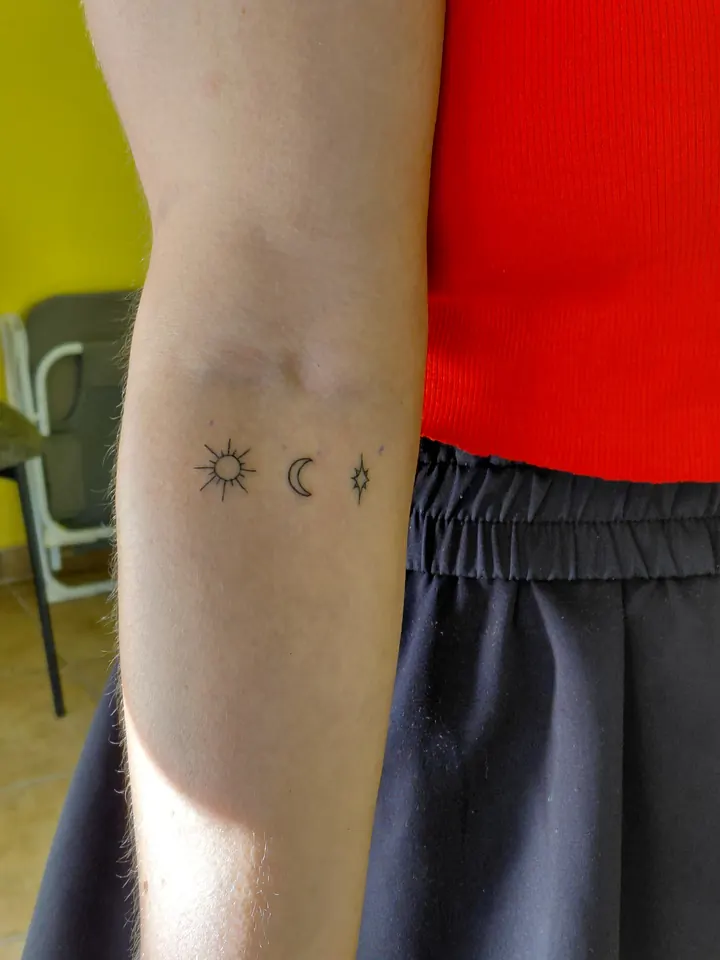 Sun, moon and star in a row on the forearm